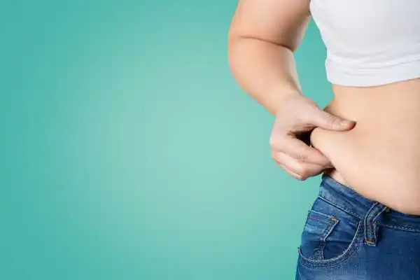 Image of woman pinching her love handles to show weight gain Handsworth